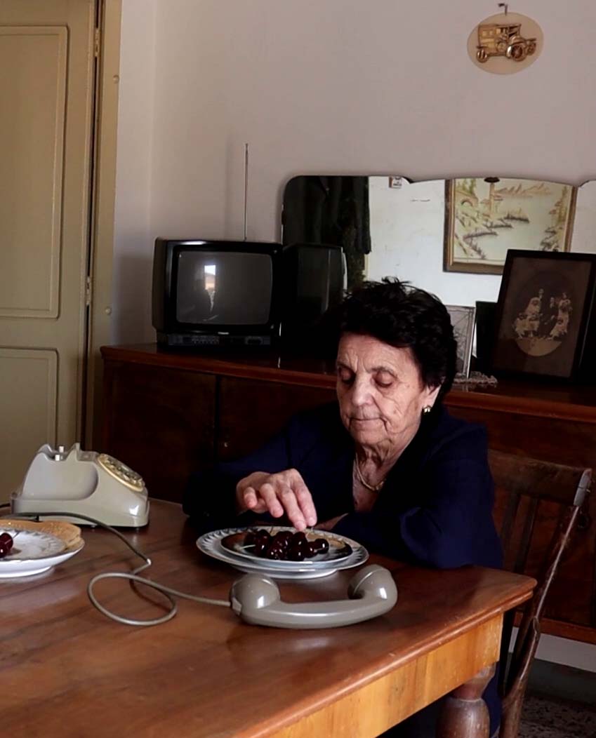 foto di un soggetto per flusso studio design di micol alessandra zarola, una signora intenta a mangiare ciliegie, mentre aspetta la telefonata da Flusso